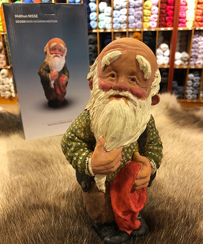 Midthun-nisse stående med lua i handa